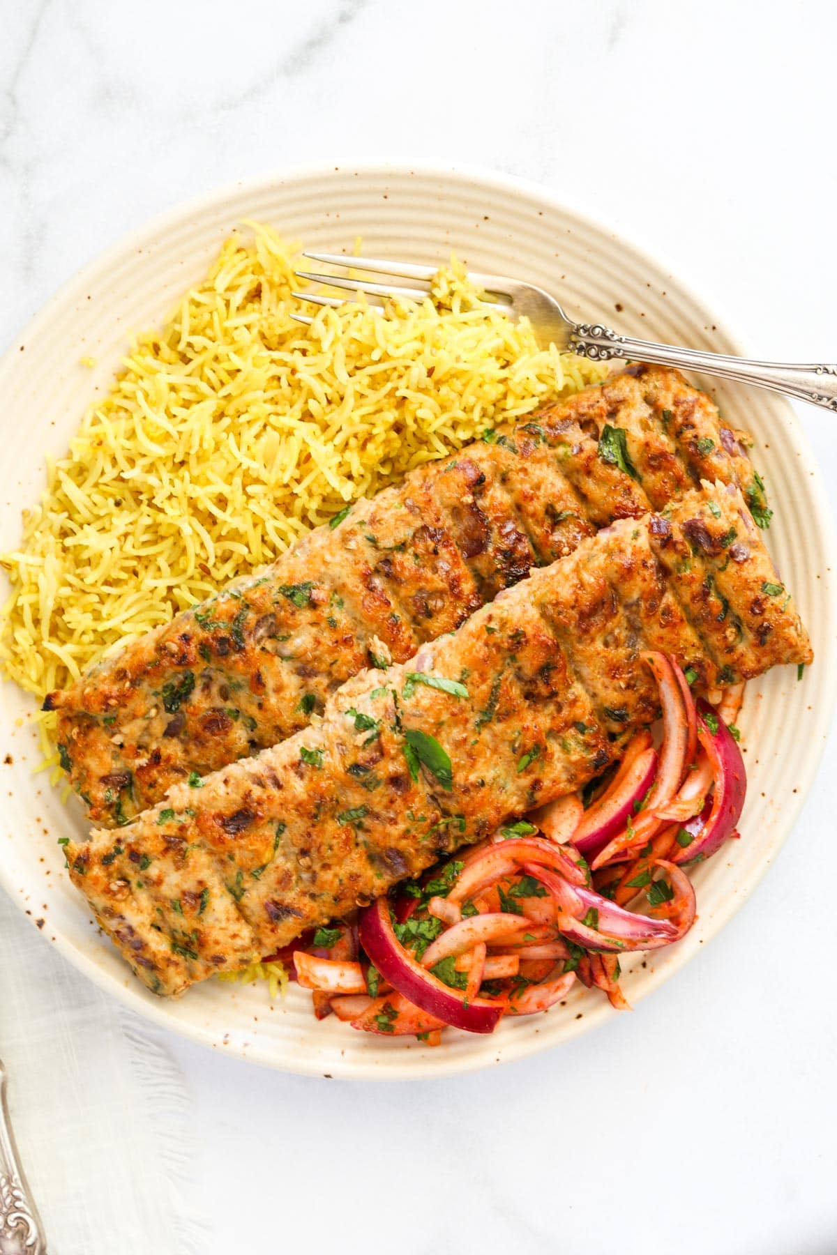 The plate came with two kebab skewers, yellow rice and a spicy onion salad served fork.