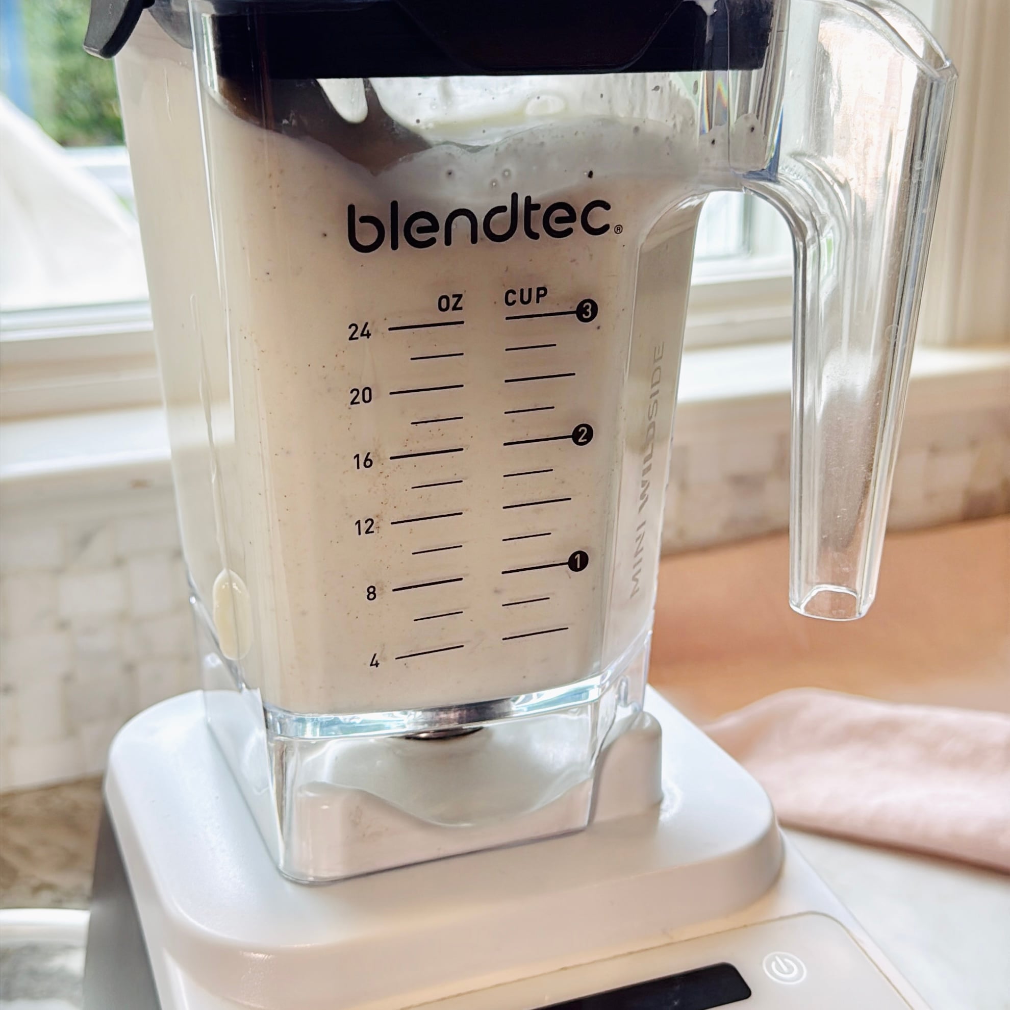 Sweet lassi being blended to frothy cream consistency in a blender.