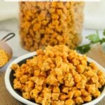A bowl of Sandge, sun-dried lentil drops, is placed on a mat with a jar of Sandge and a small bowl of yellow lentils in the background.